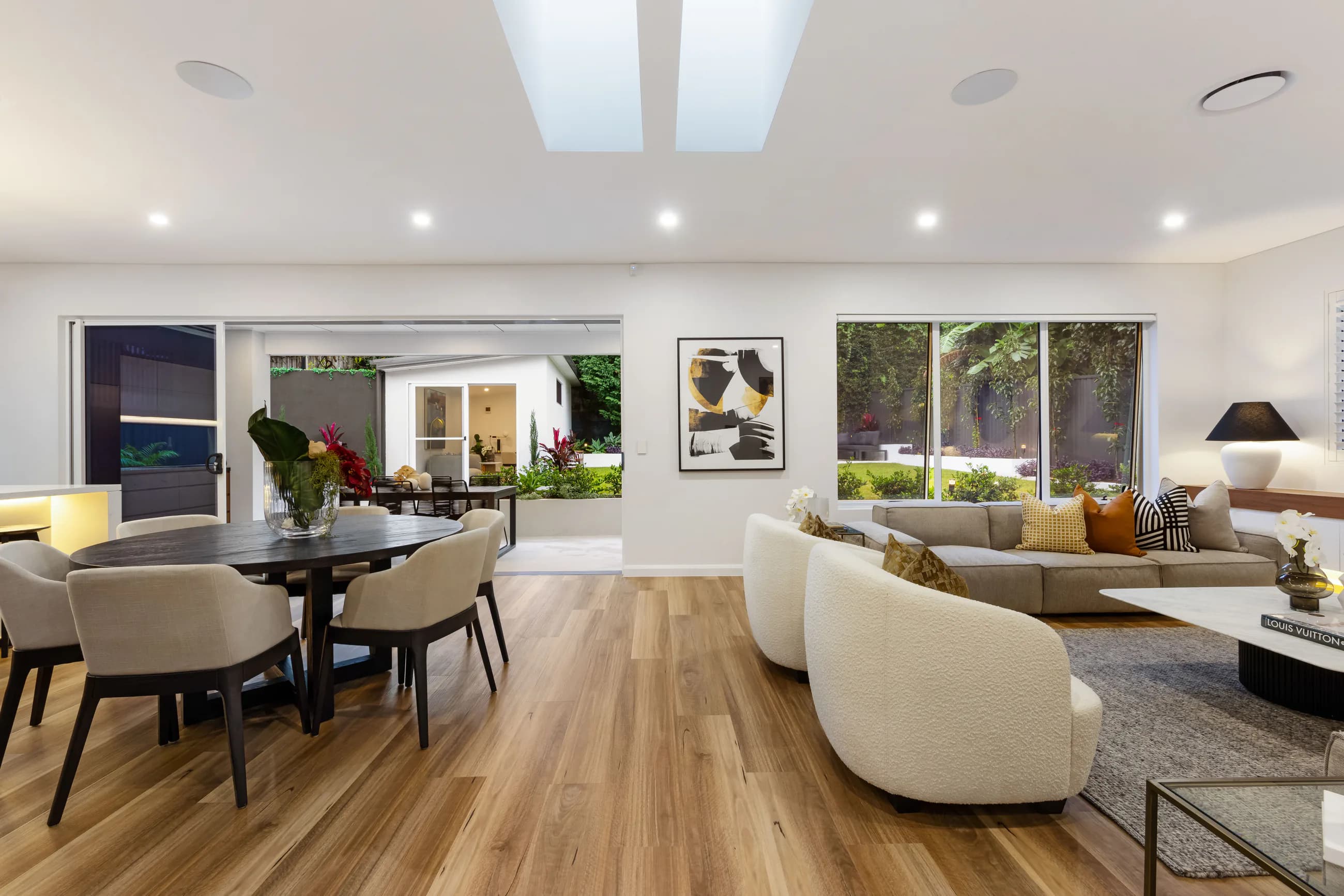 Cowell Renovation open dining and living area with timber flooring, skylights, and garden outlook